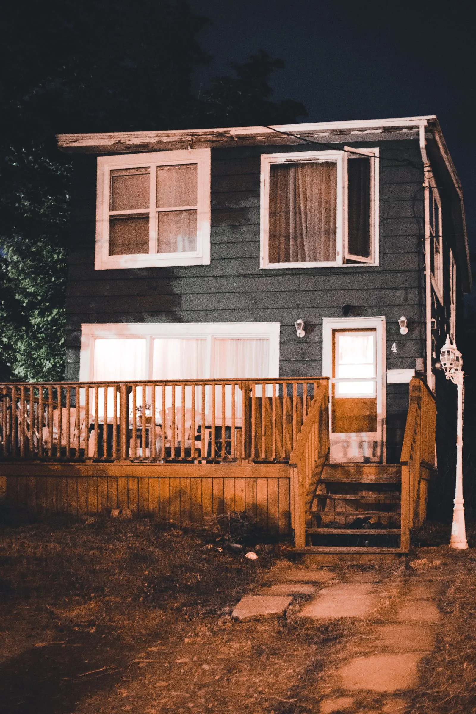 A home lit in warm white along the rooflines after dark